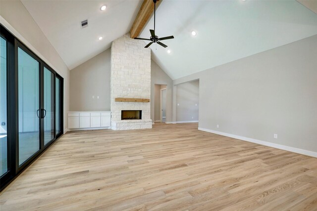 unfurnished living room featuring light hardwood / wood-style flooring, high vaulted ceiling, beam ceiling, a fireplace, and ceiling fan