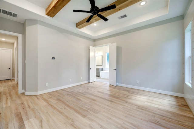 empty room featuring beamed ceiling, light wood-type flooring, ceiling fan, and a tray ceiling