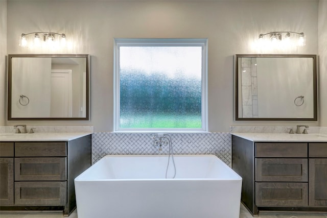 bathroom featuring a wealth of natural light, vanity, and a bathing tub