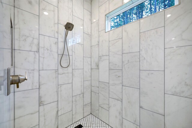 bathroom with a tile shower and plenty of natural light