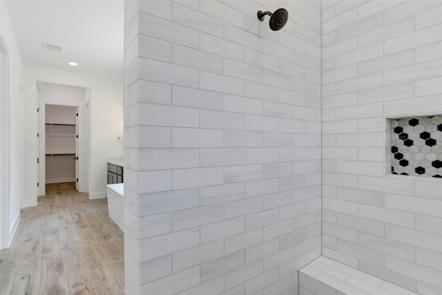 bathroom featuring vanity, wood-type flooring, and tiled shower