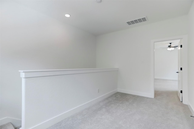 carpeted spare room featuring ceiling fan