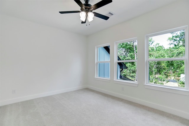 unfurnished room with carpet, ceiling fan, and a wealth of natural light