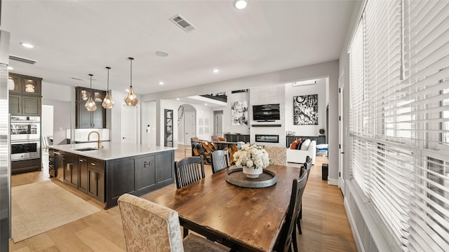 dining area with sink and light hardwood / wood-style floors