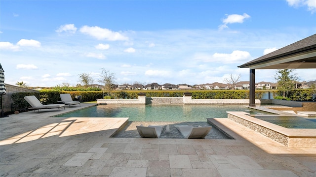 view of pool with an in ground hot tub, a patio, and pool water feature