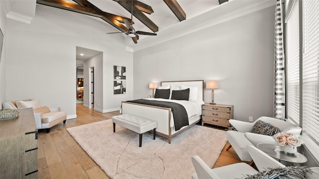 bedroom with ceiling fan, beam ceiling, light wood-type flooring, and crown molding