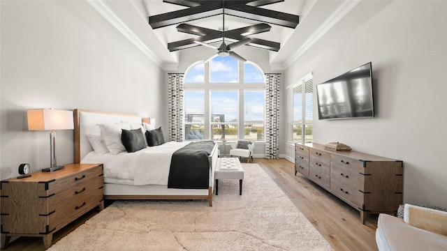 bedroom with beamed ceiling, high vaulted ceiling, and light hardwood / wood-style flooring