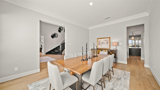 dining area featuring light hardwood / wood-style floors and crown molding