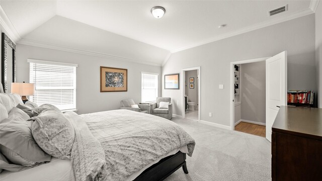 carpeted bedroom with connected bathroom, vaulted ceiling, and ornamental molding