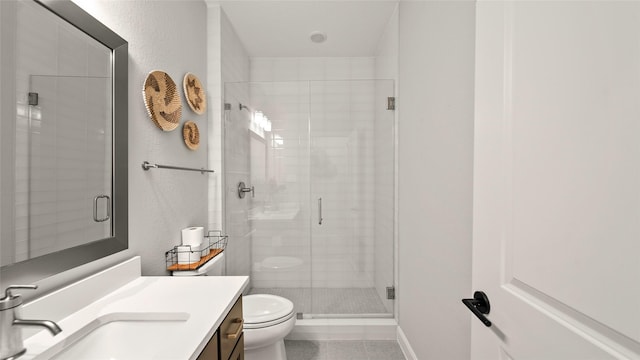 bathroom with tile patterned flooring, vanity, a shower with shower door, and toilet