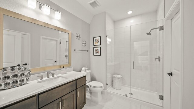 bathroom featuring tile patterned flooring, vanity, toilet, and walk in shower