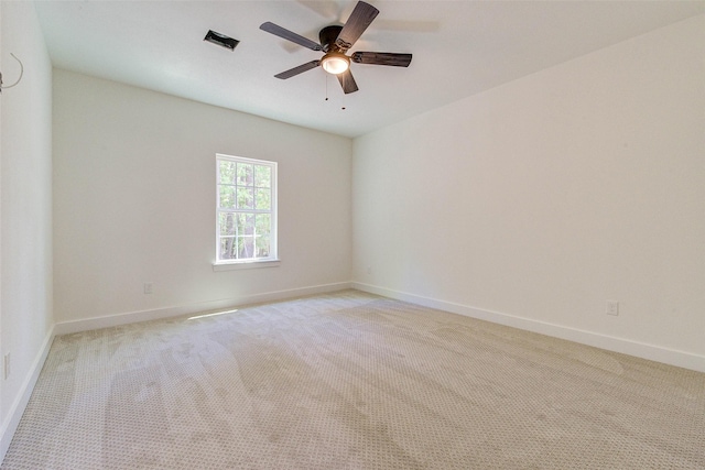 empty room with light carpet, visible vents, baseboards, and a ceiling fan