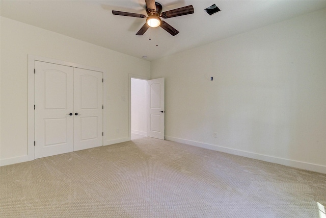 unfurnished bedroom with baseboards, ceiling fan, a closet, and light colored carpet