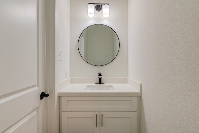 bathroom featuring a textured wall and vanity