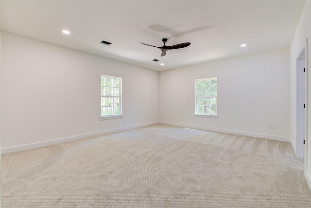 empty room with light carpet, recessed lighting, a wealth of natural light, and baseboards