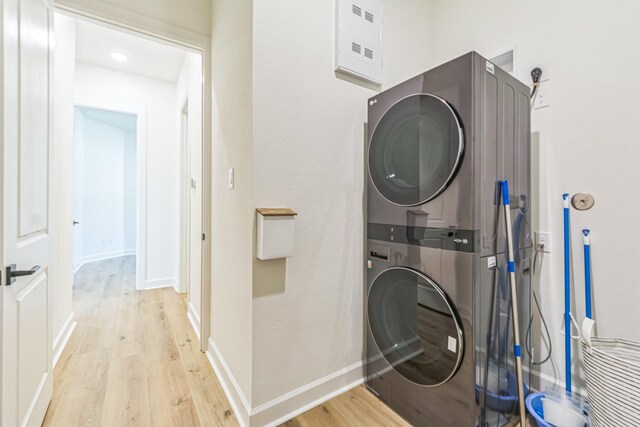 laundry area featuring light wood-type flooring and stacked washer / drying machine