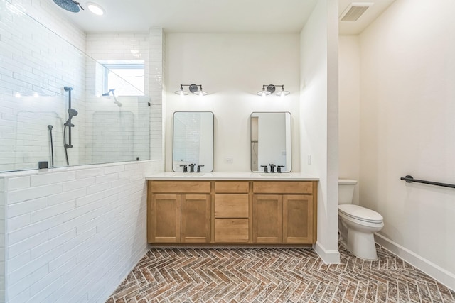 bathroom featuring vanity, tiled shower, and toilet