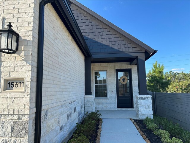 view of exterior entry featuring covered porch