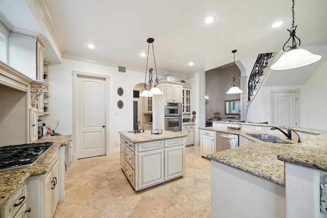 kitchen featuring light stone counters, decorative light fixtures, a kitchen island with sink, appliances with stainless steel finishes, and sink