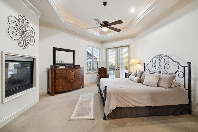 bedroom with a raised ceiling, ceiling fan, ornamental molding, and light colored carpet