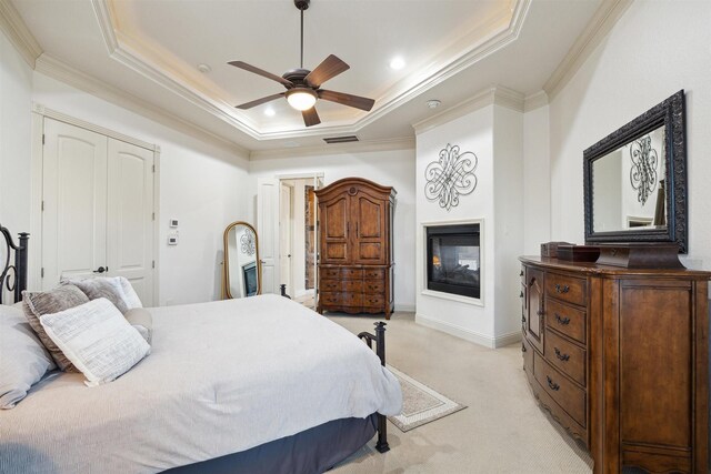 bedroom featuring a raised ceiling, light carpet, ceiling fan, and crown molding