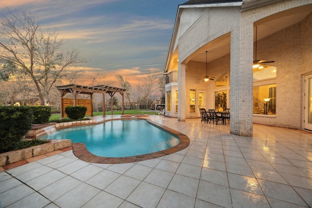 pool at dusk featuring a patio, ceiling fan, and a pergola