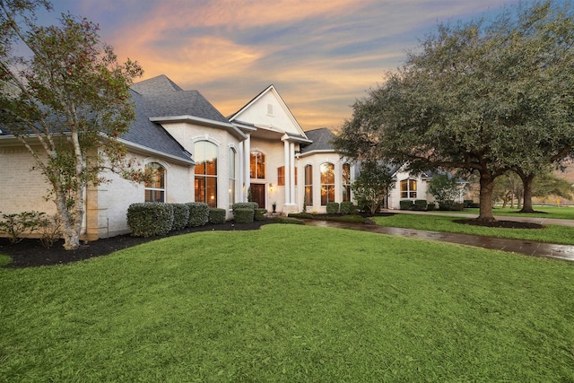 french country style house featuring a yard