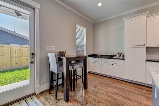 dining room with ornamental molding, recessed lighting, light wood-style flooring, and baseboards