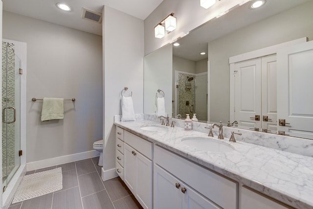 full bath with double vanity, a sink, visible vents, and baseboards