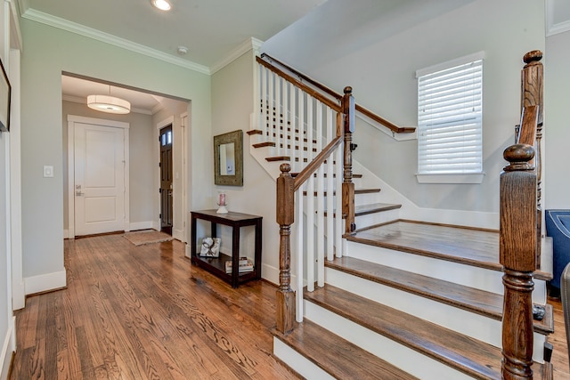 entryway featuring baseboards, stairway, wood finished floors, and crown molding