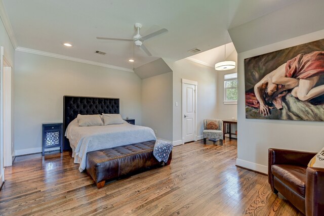 bedroom featuring ornamental molding, wood finished floors, visible vents, and baseboards