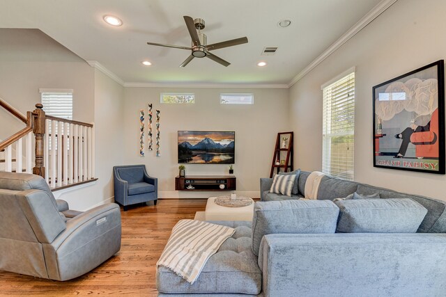 living room featuring recessed lighting, a ceiling fan, light wood-style floors, stairs, and crown molding