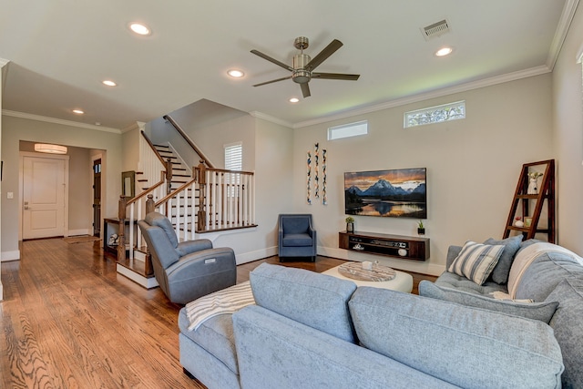 living room with wood finished floors, visible vents, baseboards, stairs, and ornamental molding