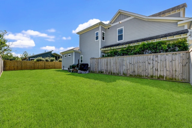 view of side of home with a fenced backyard and a lawn