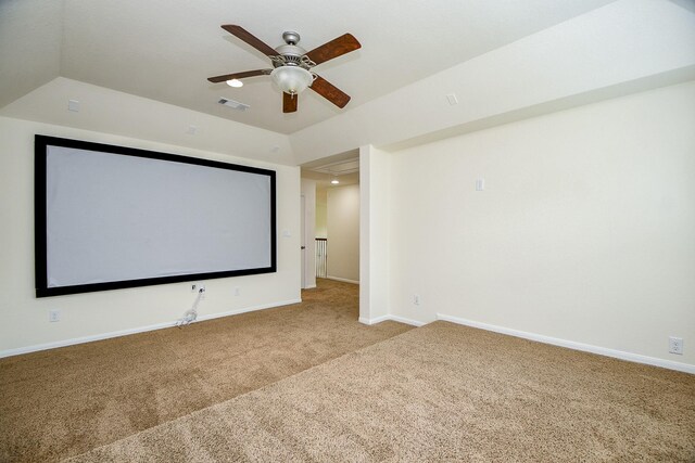 carpeted home theater featuring a tray ceiling and ceiling fan