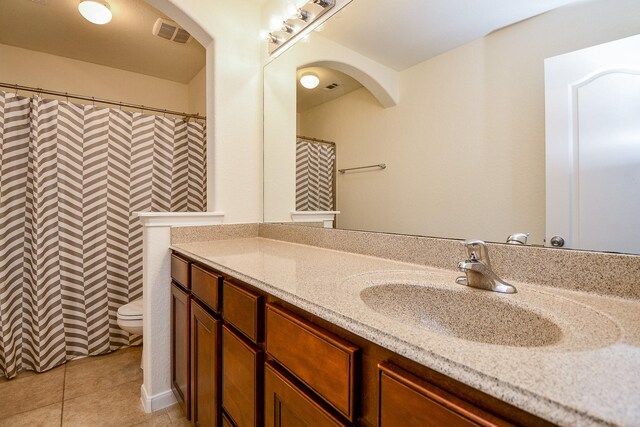 bathroom featuring tile patterned flooring, vanity, and toilet