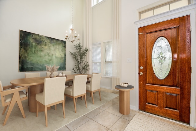 tiled foyer featuring a wealth of natural light and an inviting chandelier