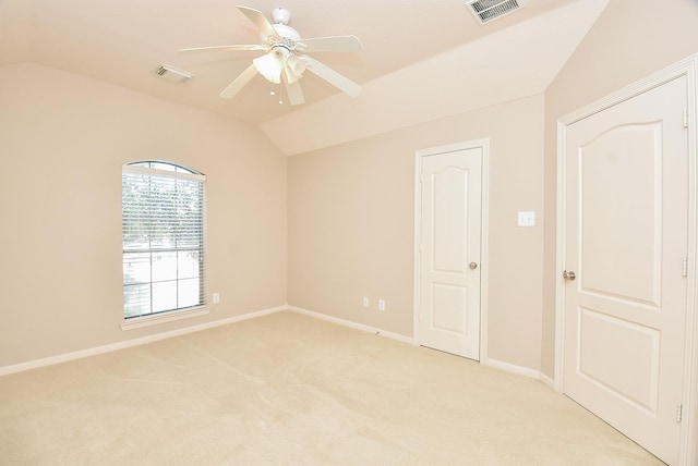 empty room with ceiling fan, light colored carpet, and lofted ceiling