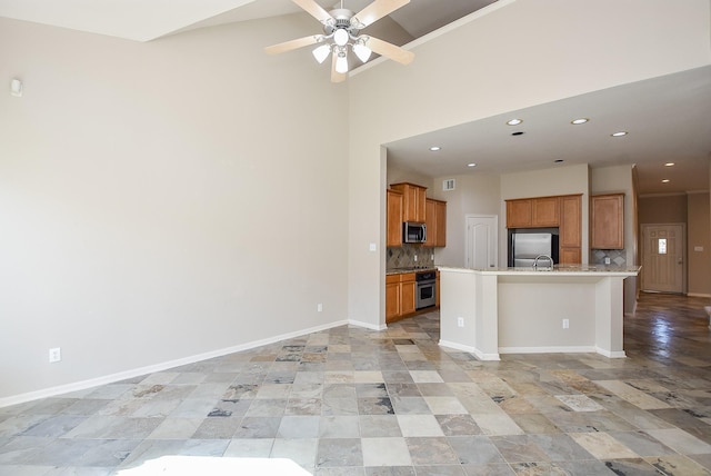 kitchen with ceiling fan, sink, tasteful backsplash, a kitchen island with sink, and appliances with stainless steel finishes