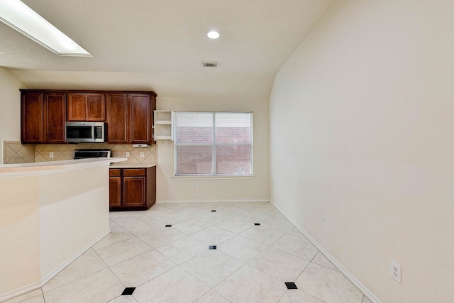 kitchen with range with electric cooktop, decorative backsplash, light tile patterned floors, and lofted ceiling