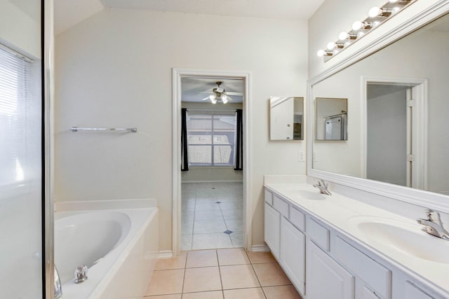 bathroom with a washtub, vanity, tile patterned flooring, and a wealth of natural light