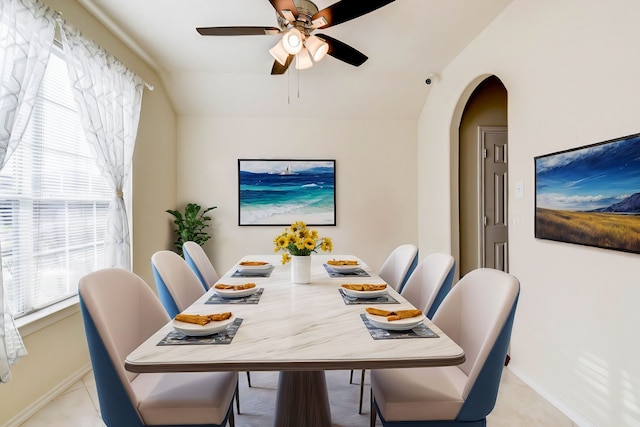 dining room featuring ceiling fan, light tile patterned floors, and vaulted ceiling