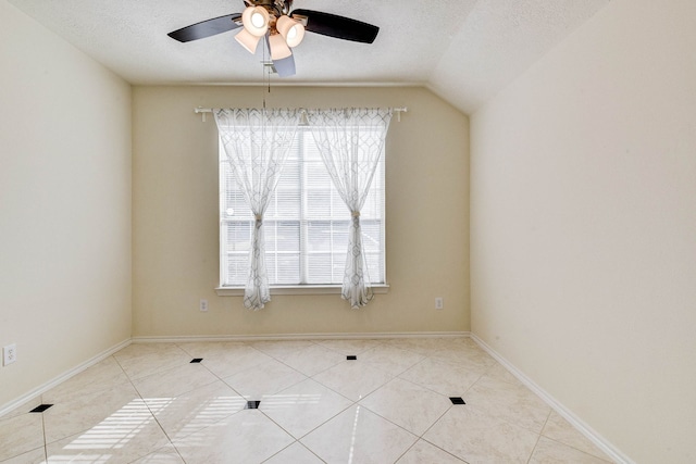 tiled spare room featuring ceiling fan, a textured ceiling, and vaulted ceiling