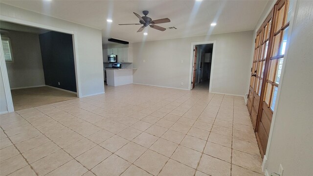 tiled empty room featuring ceiling fan