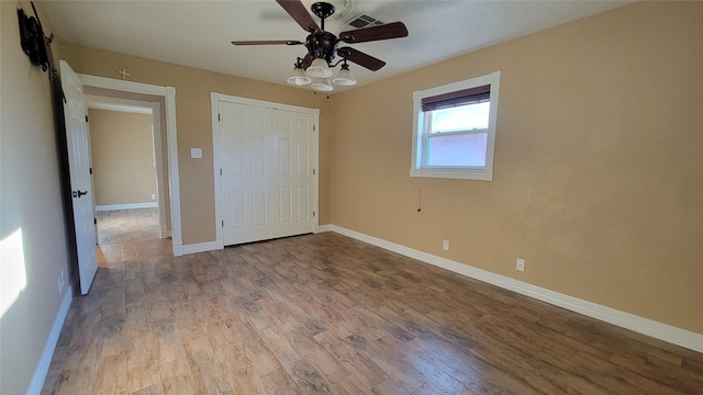 unfurnished bedroom featuring a closet, light hardwood / wood-style flooring, and ceiling fan