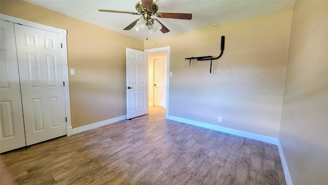 unfurnished bedroom featuring a closet, light hardwood / wood-style floors, and ceiling fan