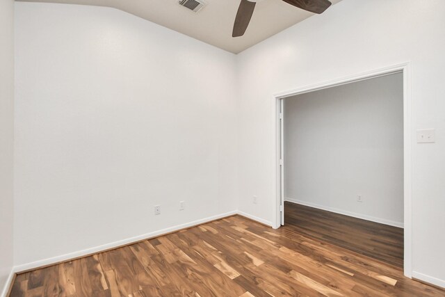 empty room with ceiling fan, dark hardwood / wood-style flooring, and lofted ceiling