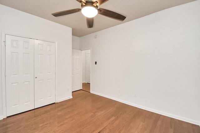 unfurnished bedroom with hardwood / wood-style floors, a closet, and ceiling fan