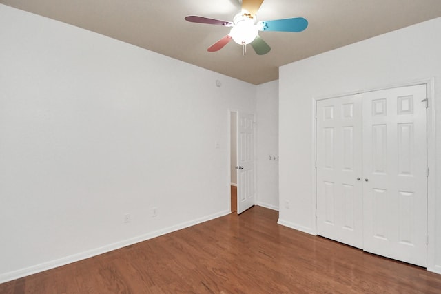 unfurnished bedroom featuring ceiling fan, dark hardwood / wood-style floors, and a closet