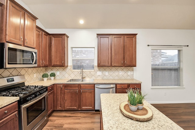 kitchen with dark hardwood / wood-style floors, sink, light stone countertops, and stainless steel appliances